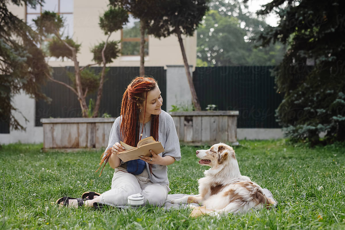 Woman paying attention to her dog during reading