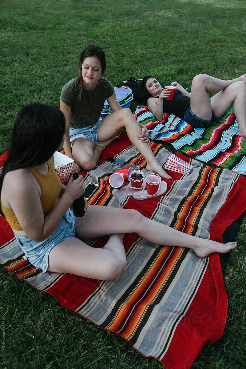 young women watch an outdoor movie in backyard