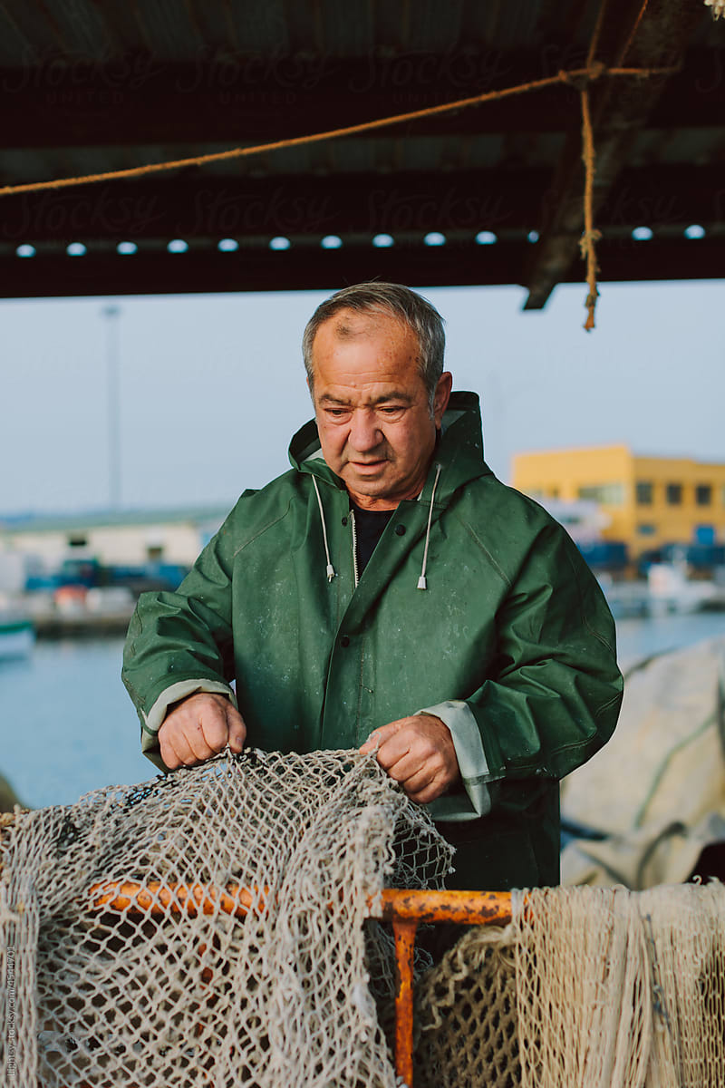 Old fisherman preparing nets before set sail