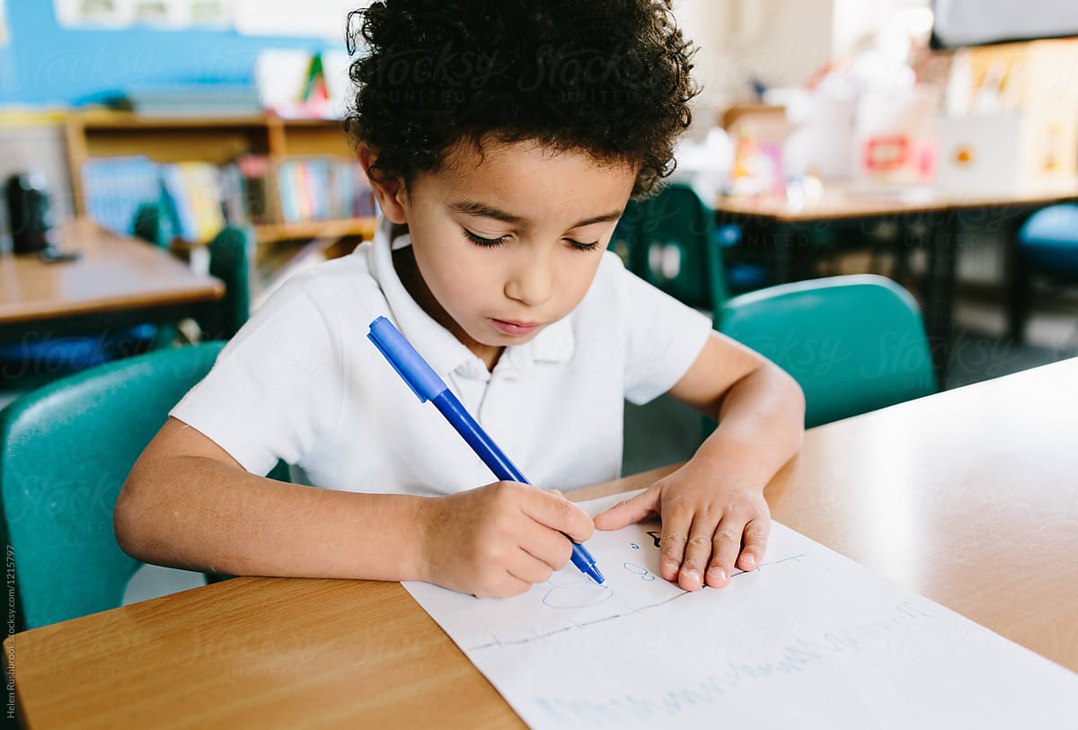 A 4 year old mixed race boy practising his writing.