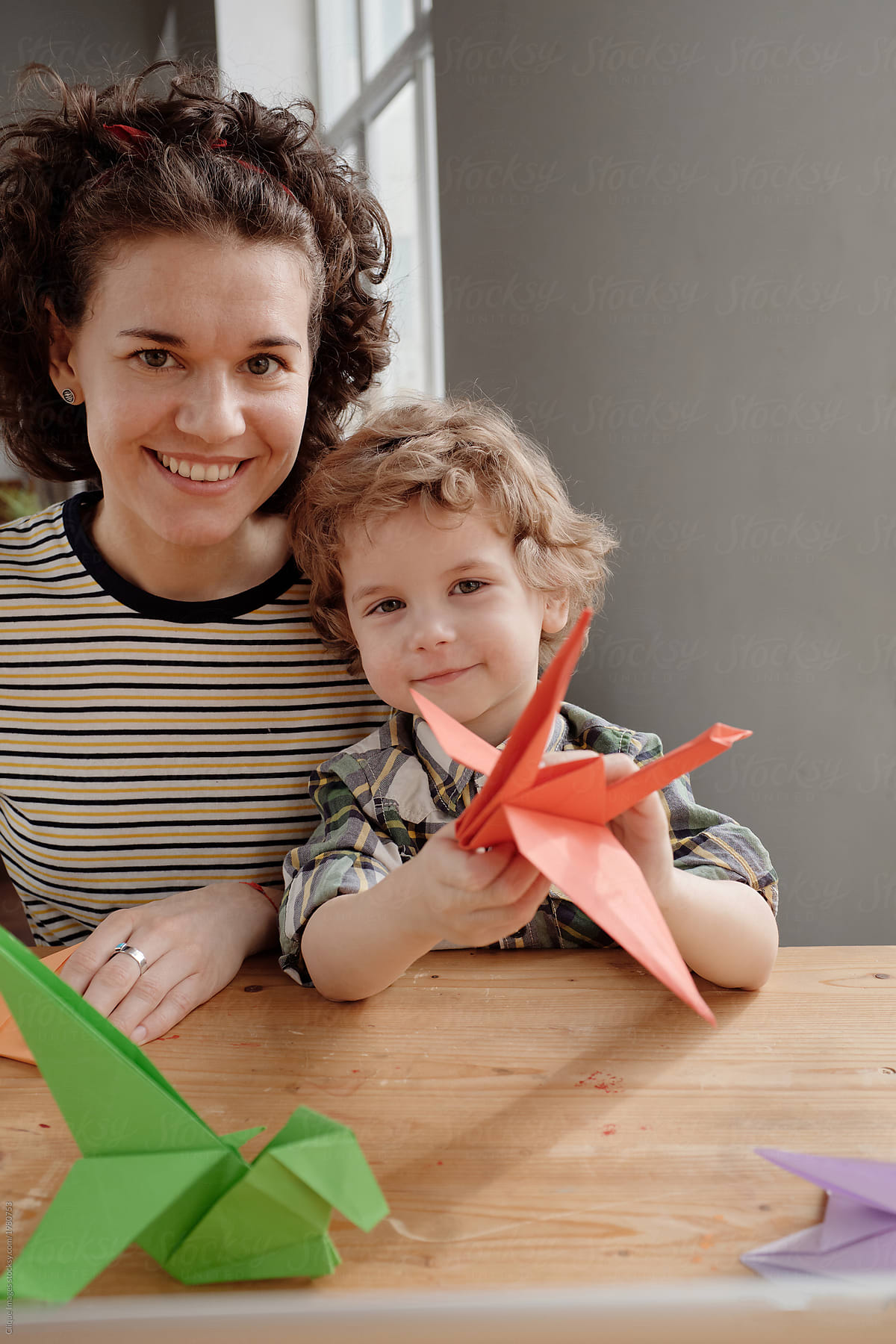 Cheerful mother and son with origami