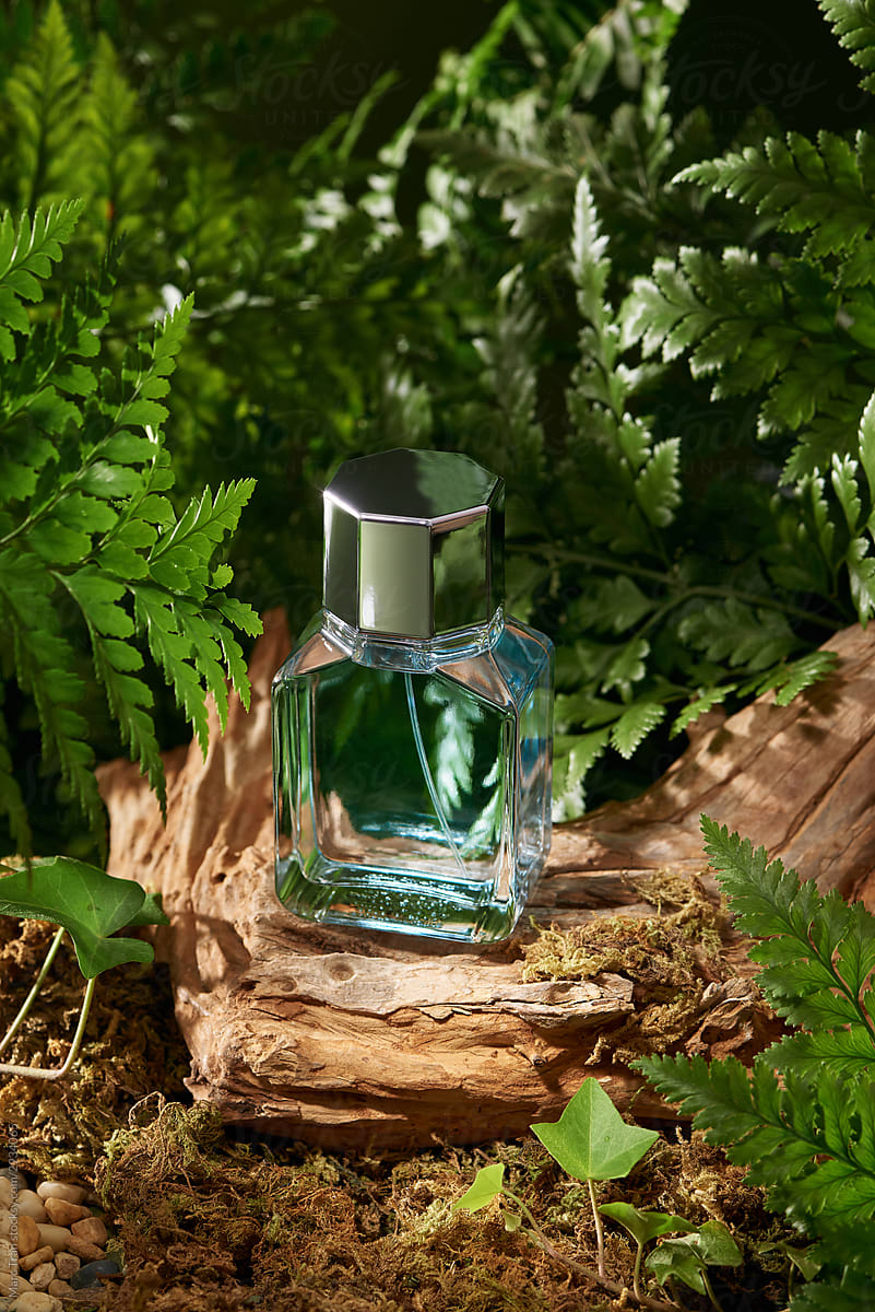 Elegant perfume glass bottle on garden background.