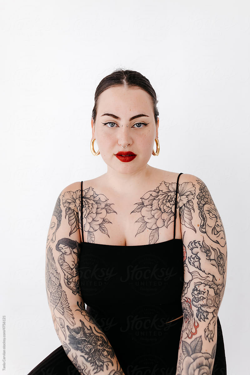 Confident tattooed woman in studio