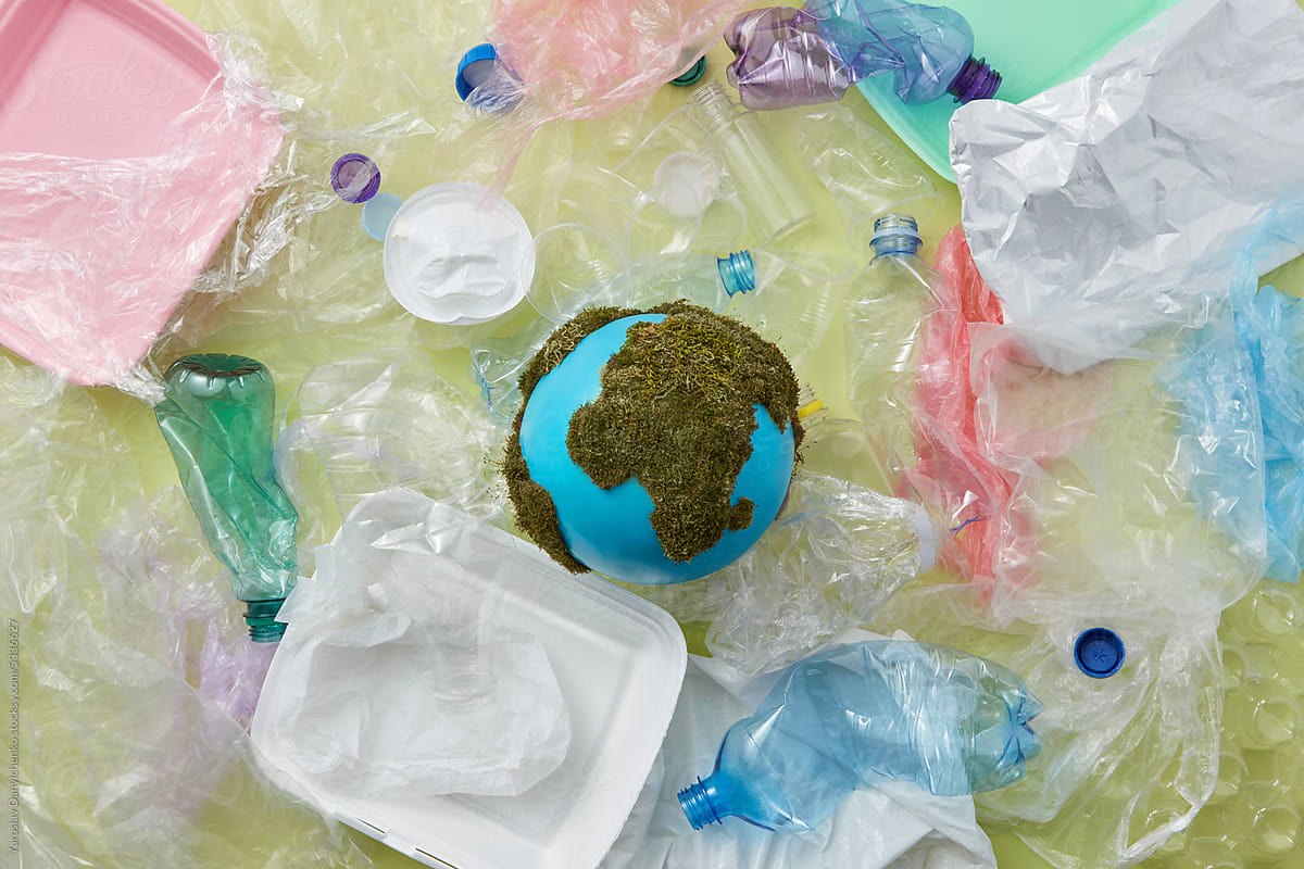 Earth globe laid amidst various waste.