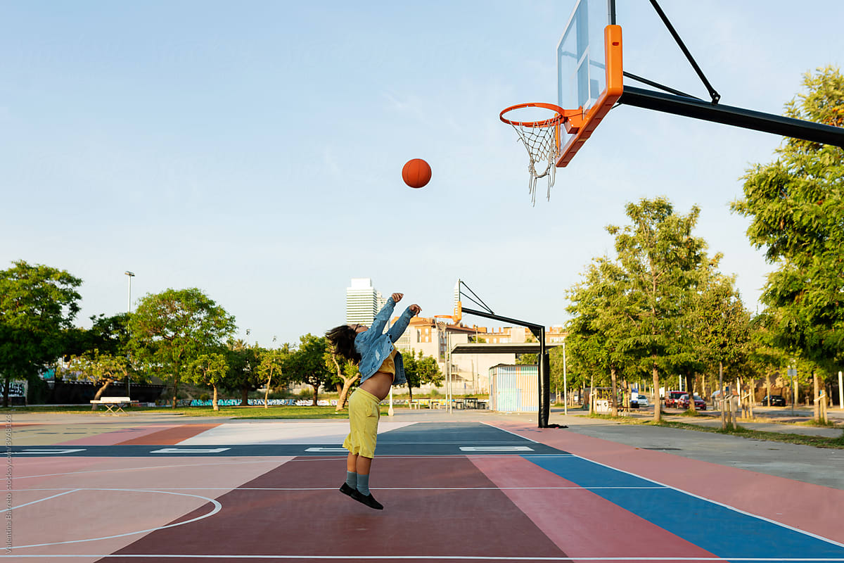 Boy throwing basketball to basket