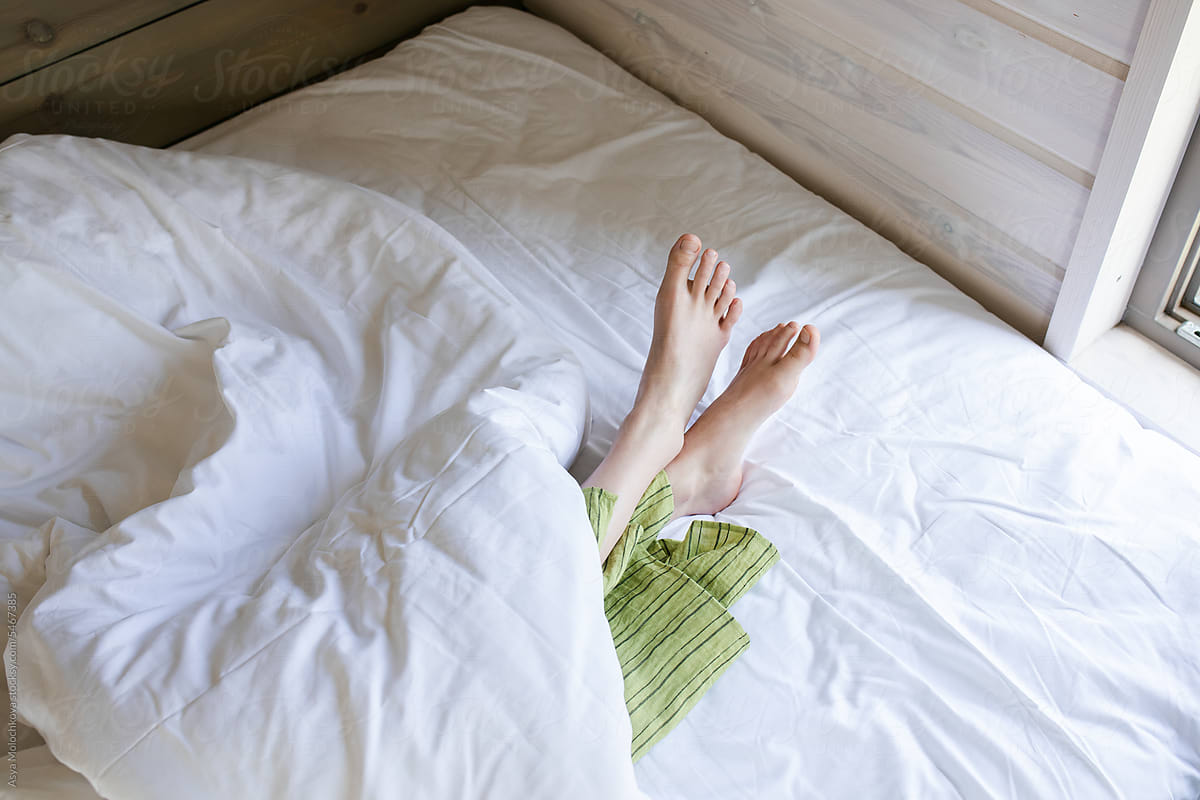 Woman\'s feet peeking out from under the covers