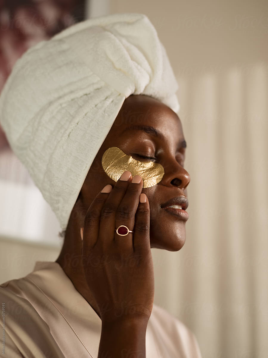Woman touching golden eye mask on face