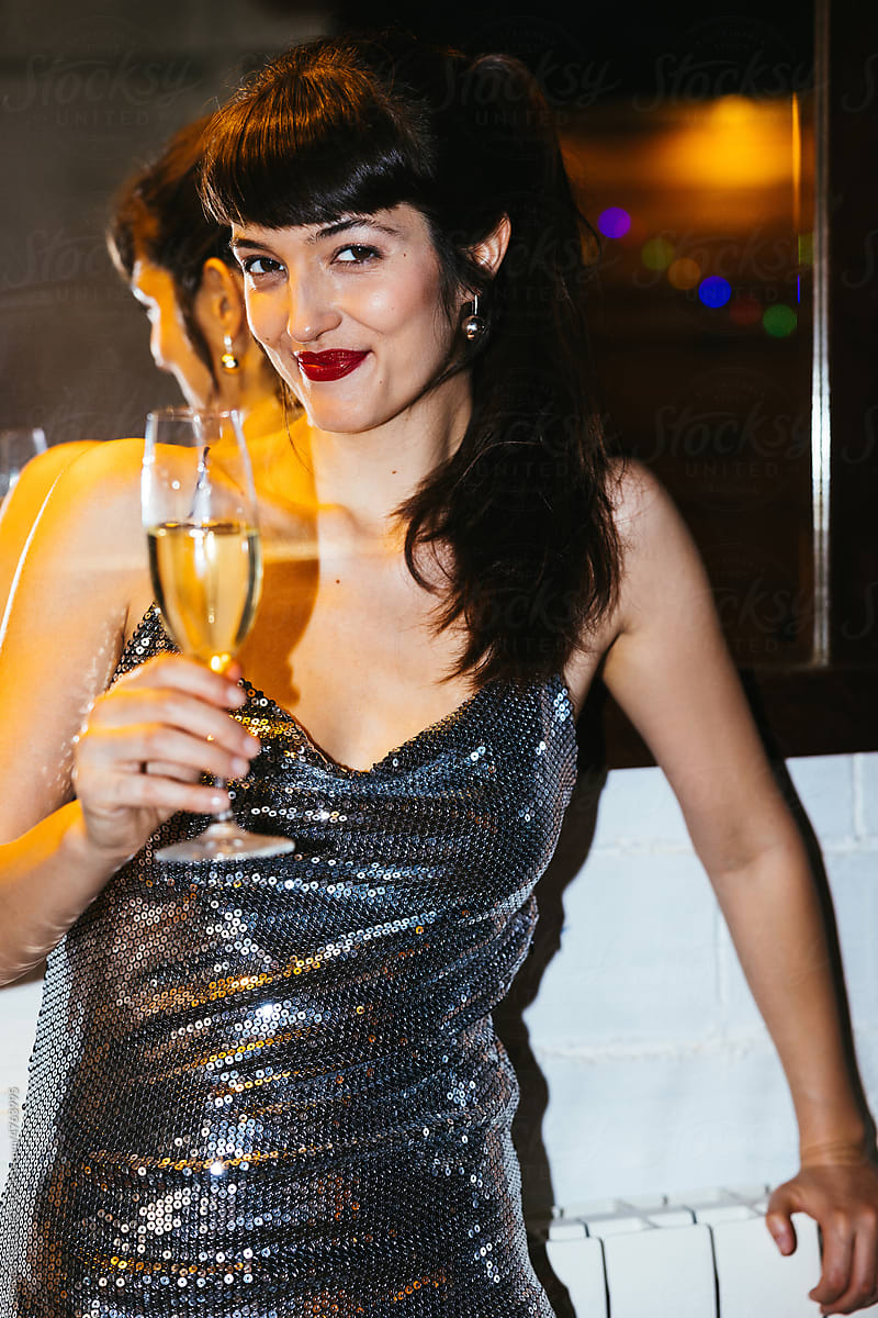Happy woman with champagne glass smiling at camera