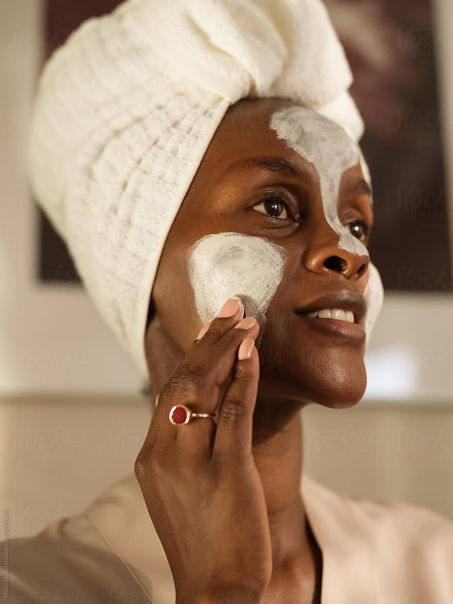 Beautiful woman applying clay mask