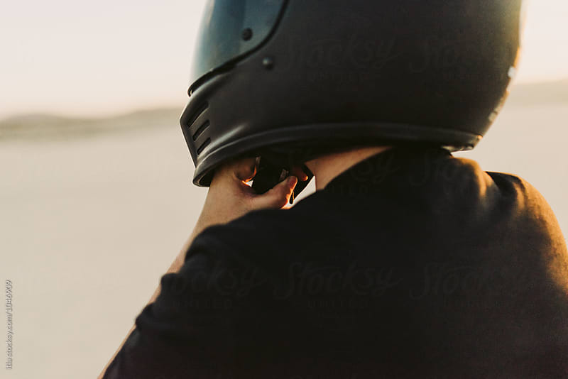 Woman putting on motorcycle helmet