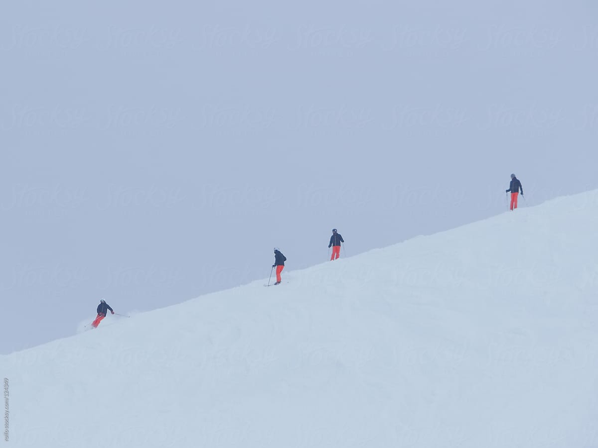 Skiers descending a ski slope on a cold winter day