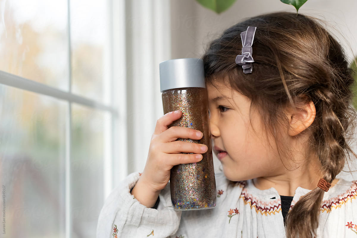 Child looking closely at calm down jar
