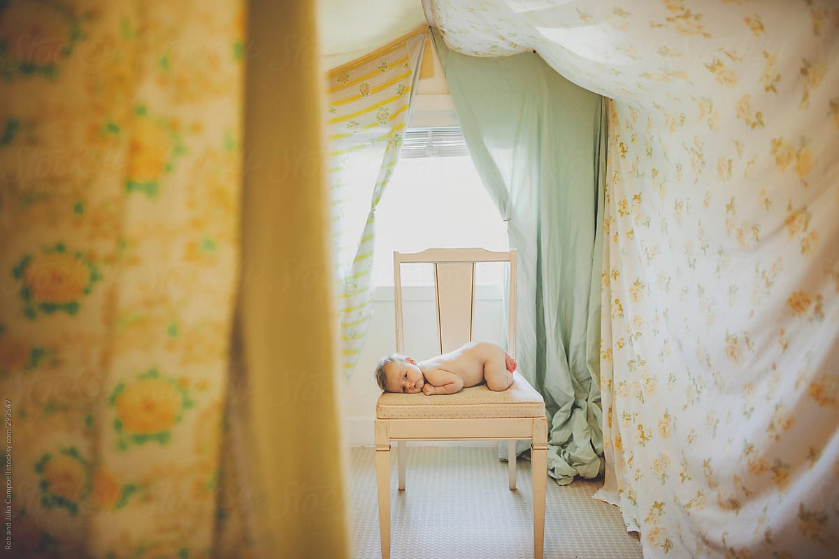 Creative portrait of baby girl lying on vintage chair