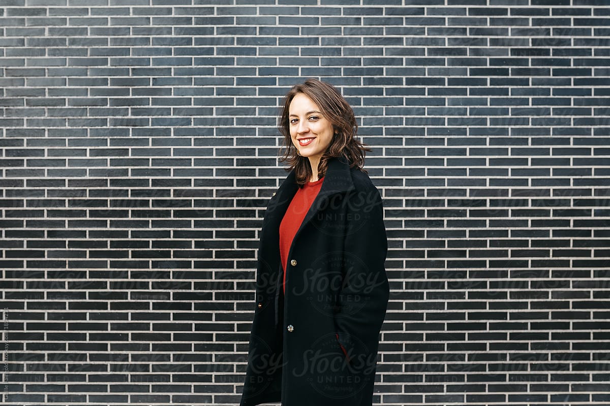 smiling brunette businesswoman in black coat