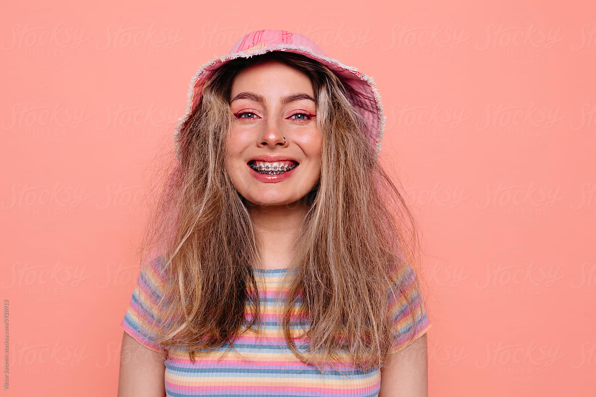 Smiling woman in casual outfit on peachy background
