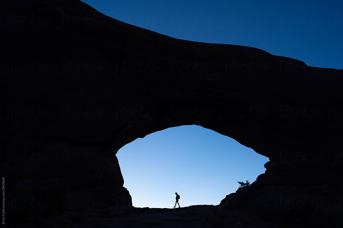 Woman Walking in North Window Arch in Arches National Park, Utah