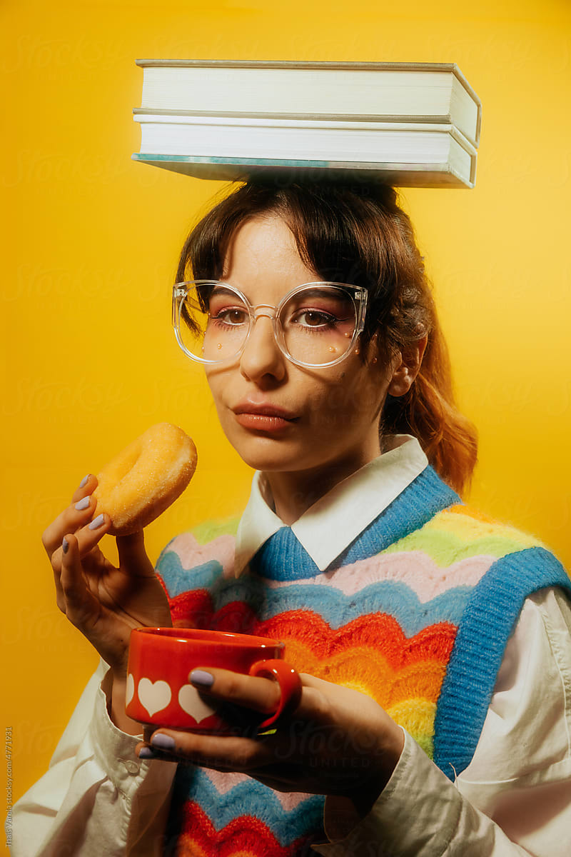 NERDY WOMAN HOLDING TWO BOOKS ON HER HEAD WHILE DRINKING COFFEE
