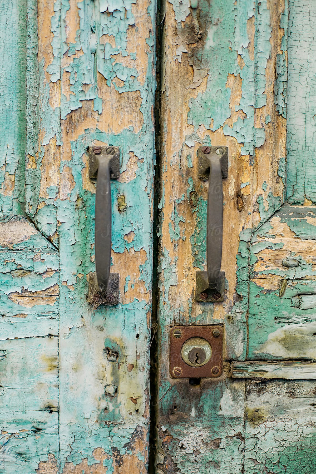 Rusty lock and grips on ruined blue wooden door