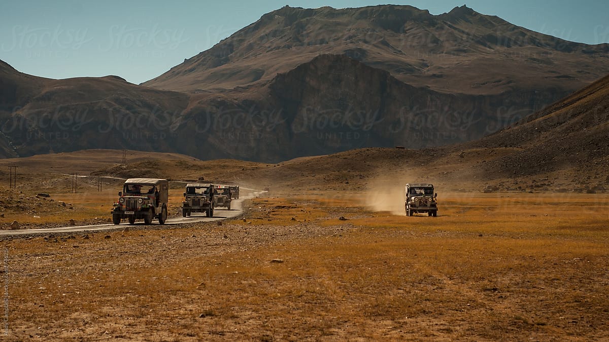 Off-road vehicles crossing a plain in the Himalayas.