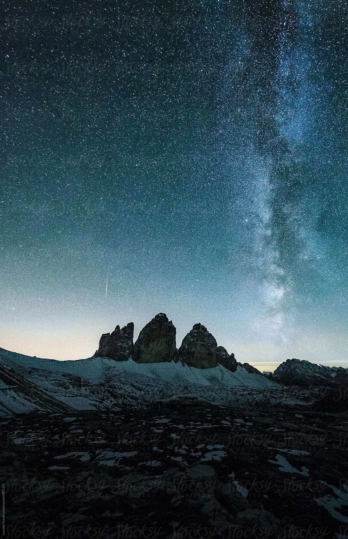 blue milky way above the famous three peaks in the italian alps in a clear night