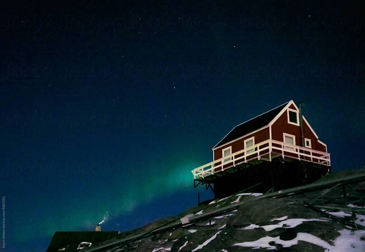 Arctic winter - aurora borealis northern lights over Greenlandic house