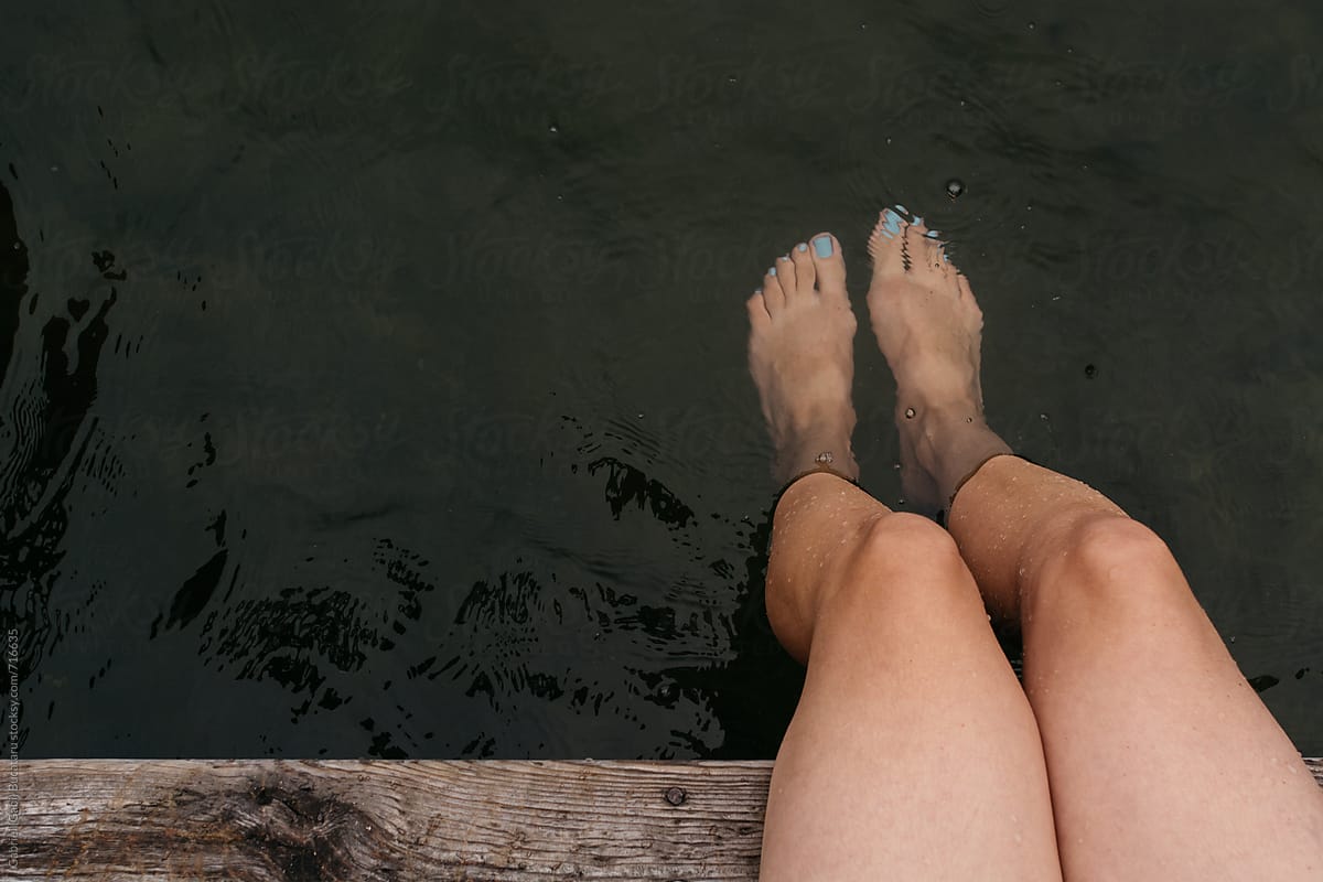 Woman\'s legs in lake water from above