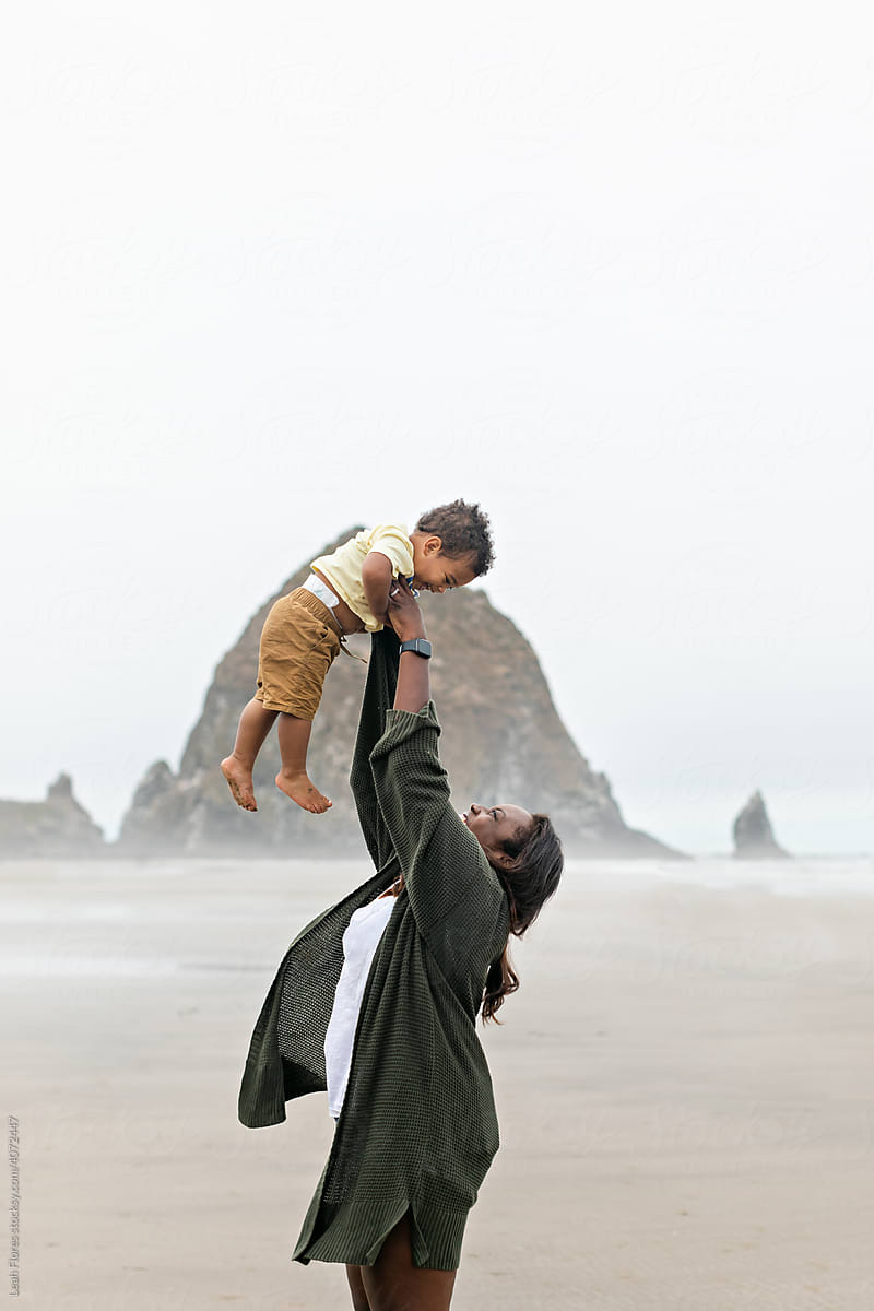 Mother Throwing Toddler in the Air While at the Beach