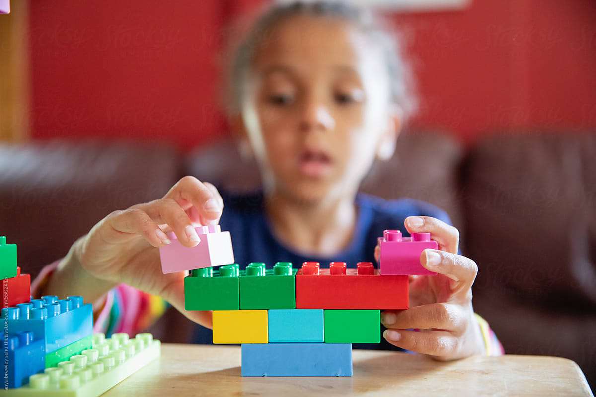 Closeup of lego blocks being assembled by a child