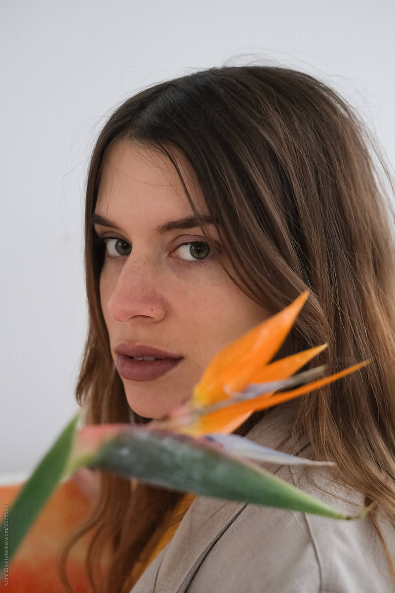 Portrait of Beautiful Woman With Orange Flower in First Plan