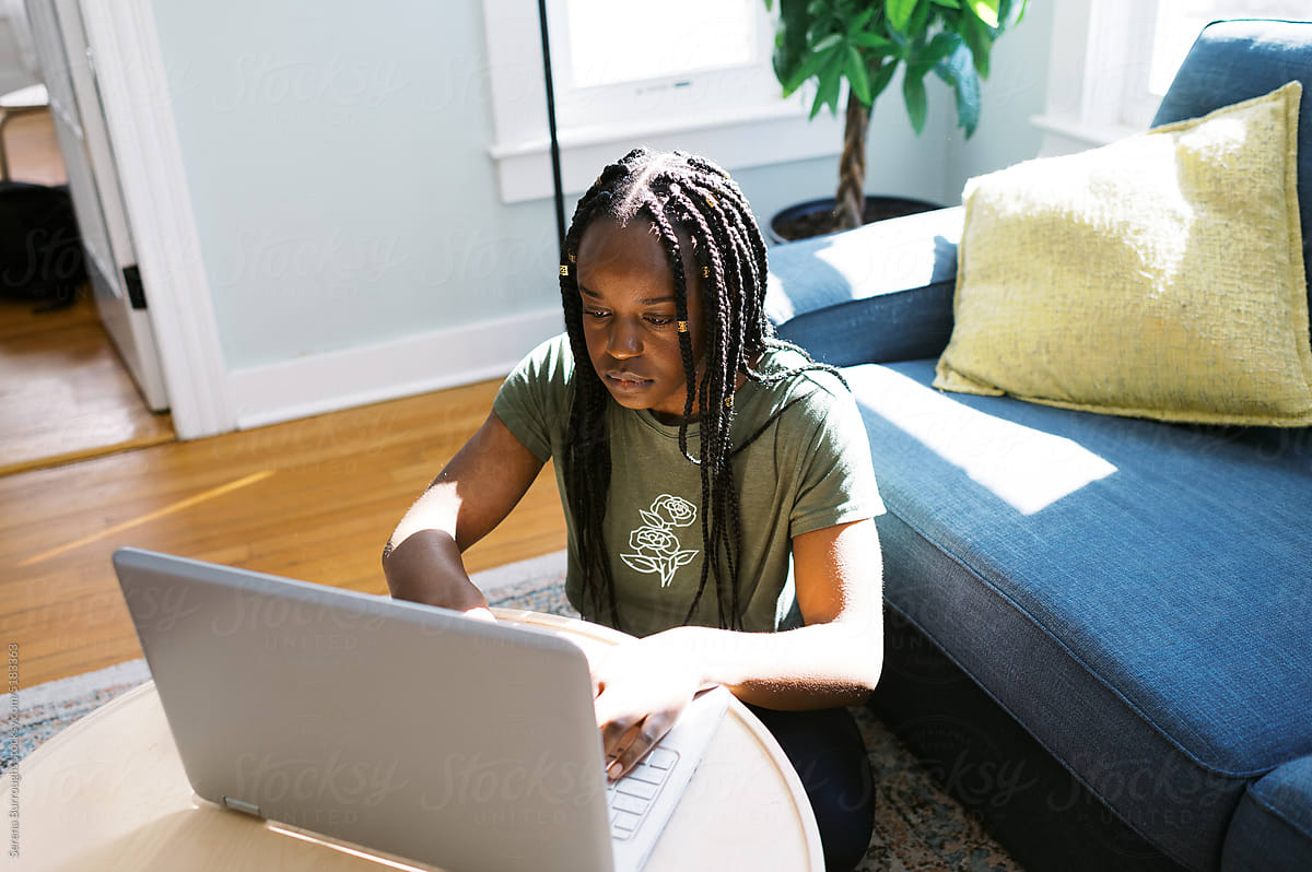 smiling black woman typing on her computer