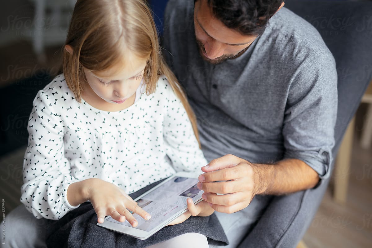 Father and Daughter Reading from Tablet Together