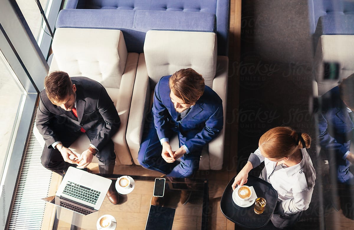 Waitress Brings Drinks to Businessmen Sitting at a Cafe