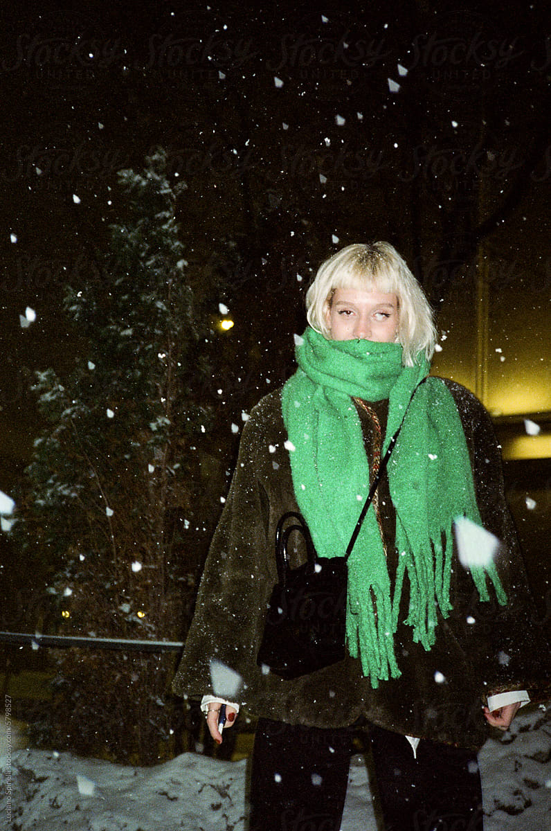Girl with green scarf in the snowstorm with snow flake in front eye