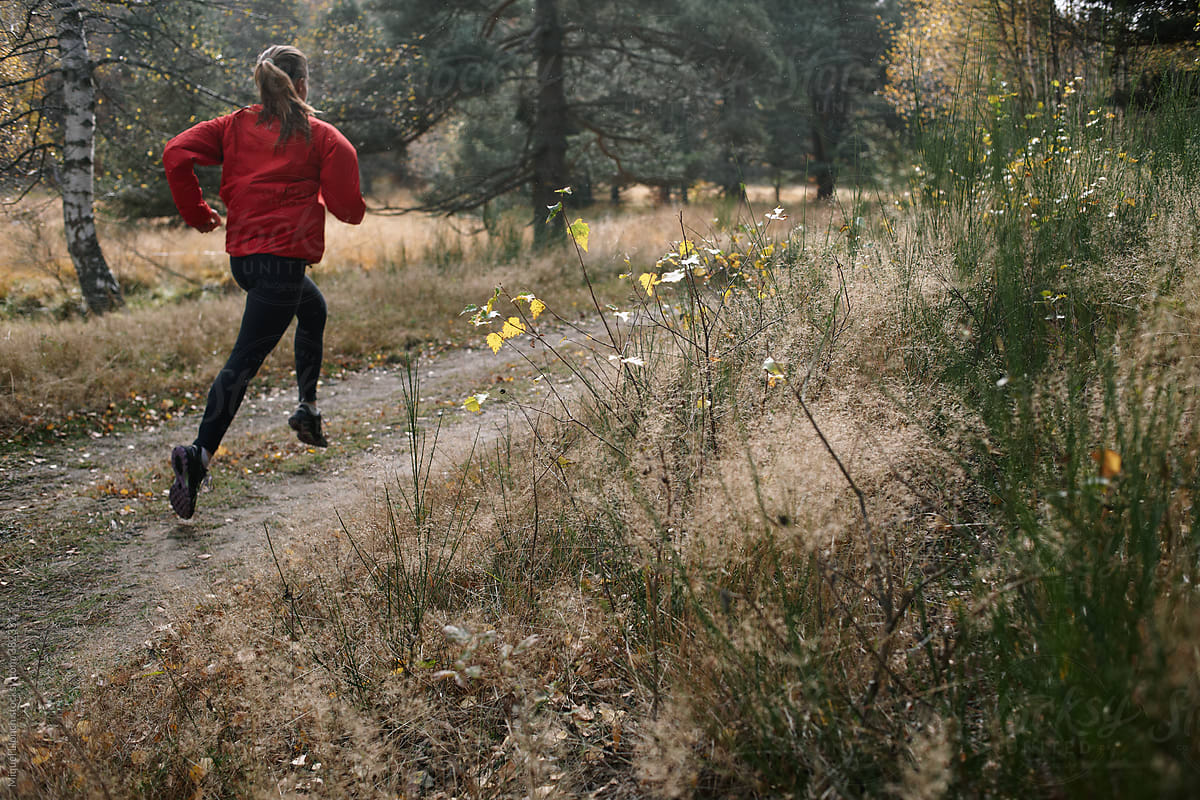 Young woman running in a forest trail