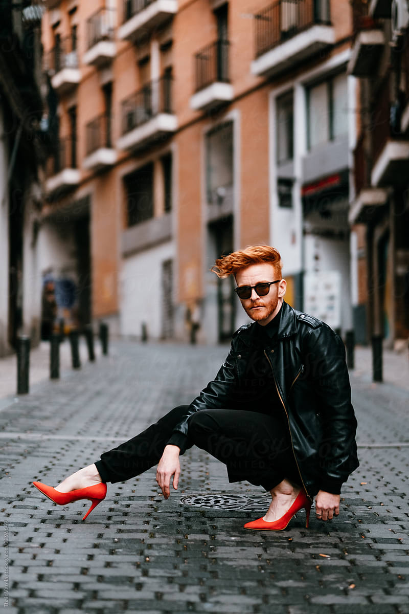Redhead cool man walking down the street on red high heels