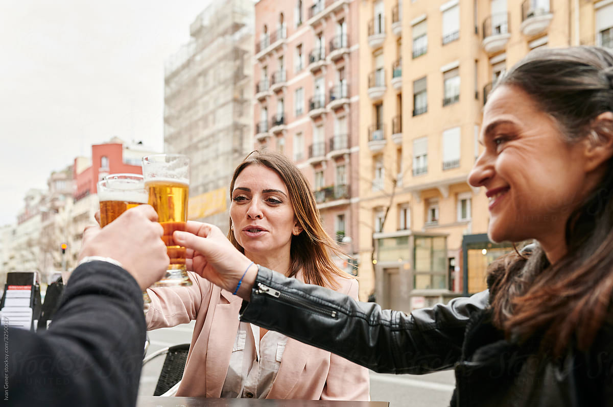 Friends toasting with beers outside