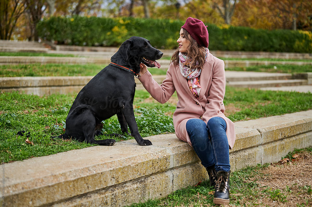 Young woman with dog resting in park