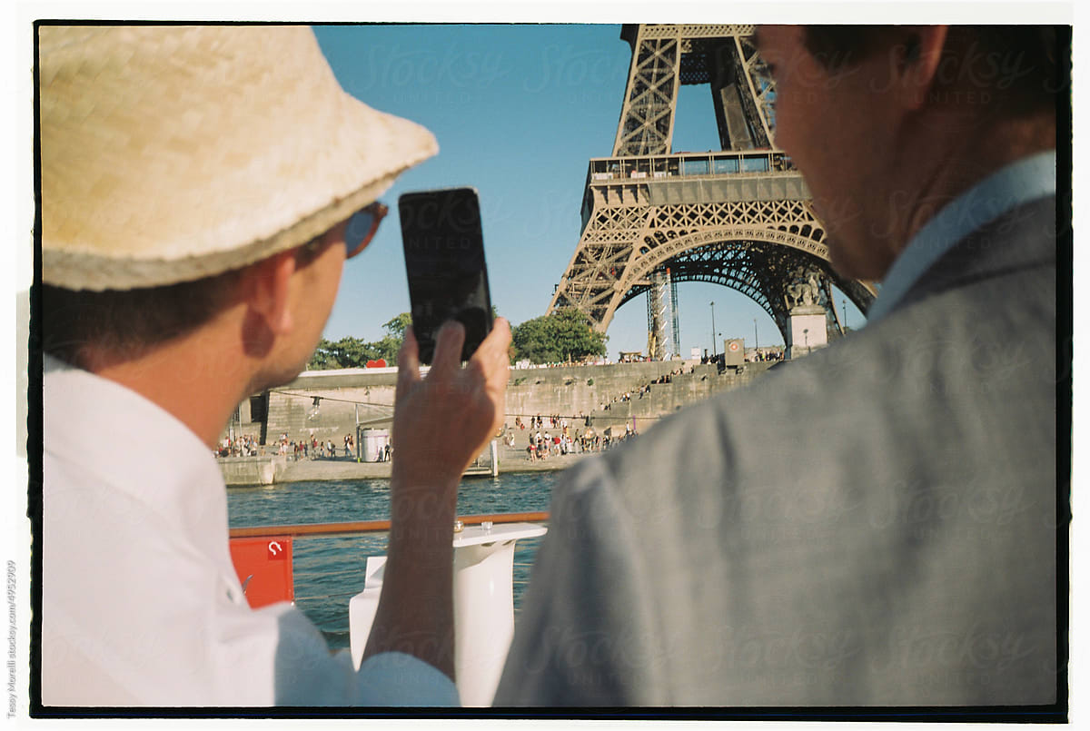 Anonymous candid tourists taking photo of tour eiffel