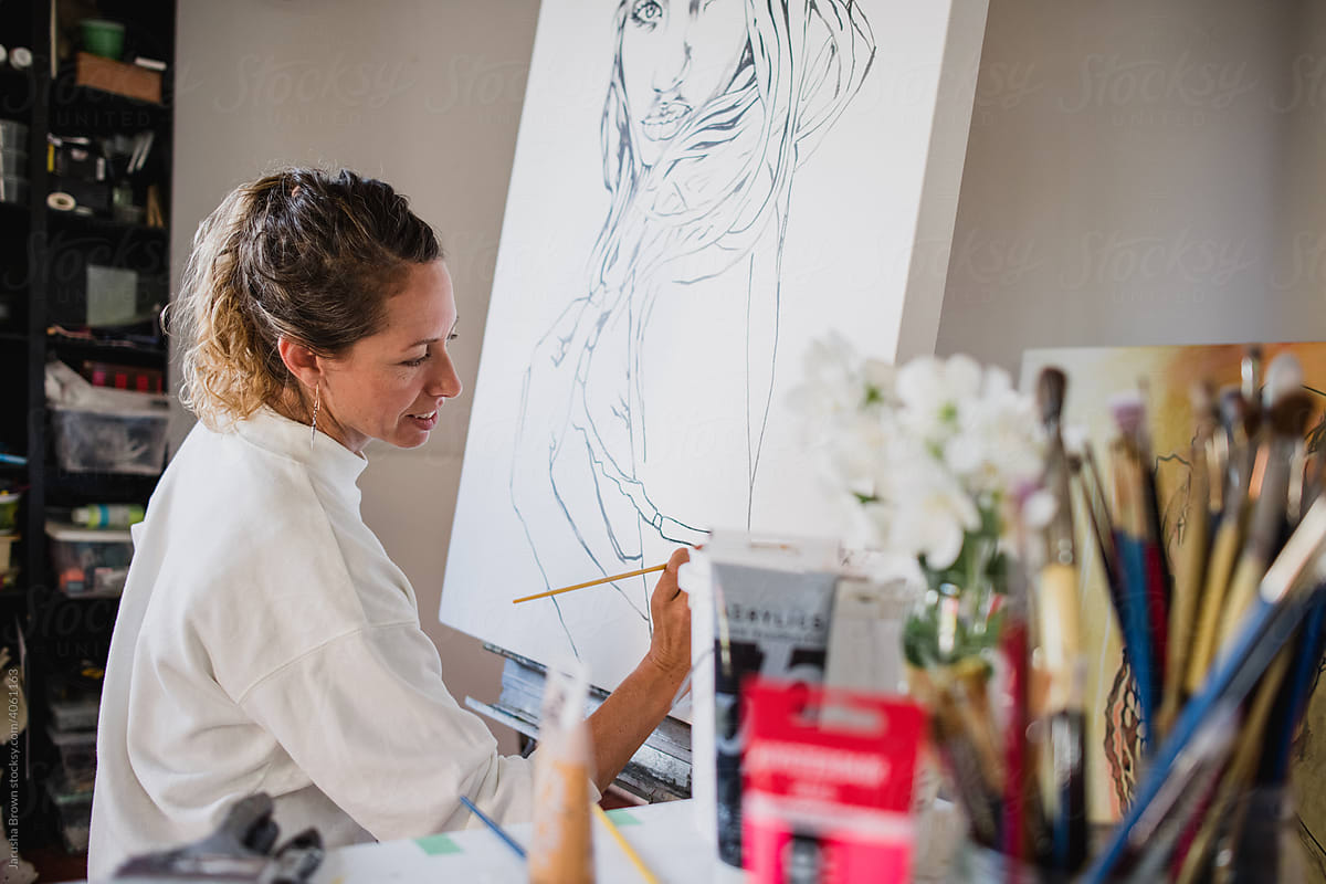 Woman paints a female portrait.