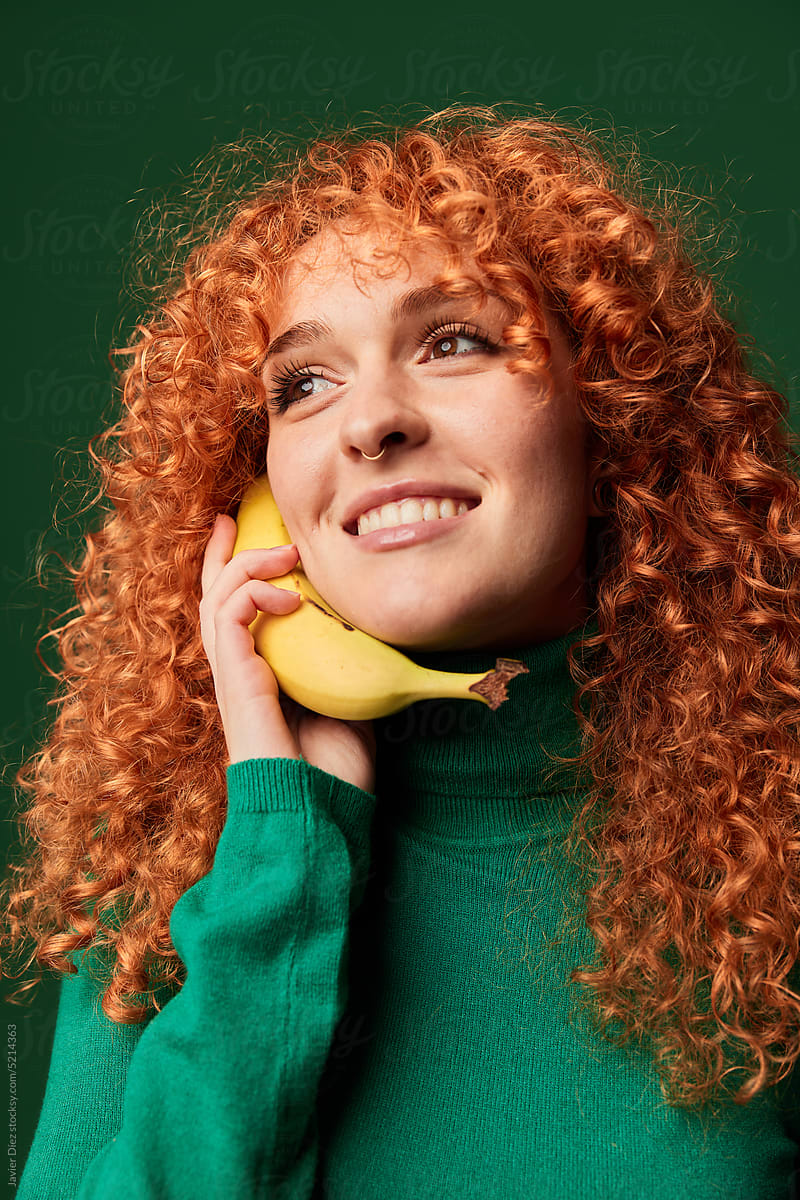Smiling woman using banana as phone
