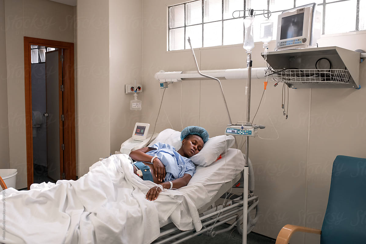 Pregnant black woman sleeping near medical machines