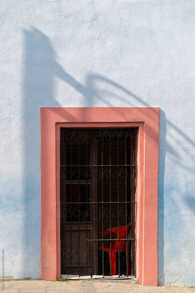 Red Doorway with iron gate on a blue building