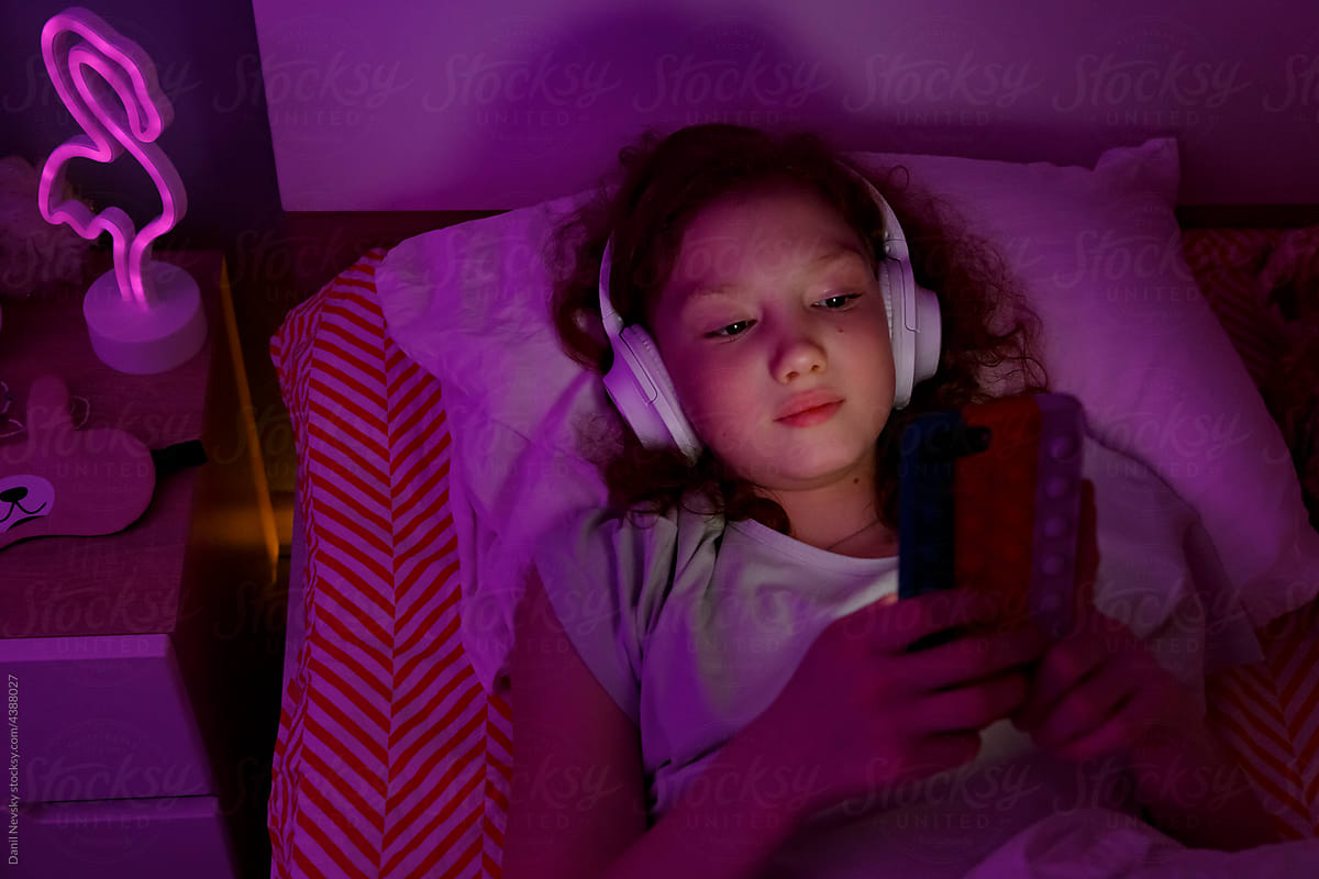 Child watching video on mobile phone at night