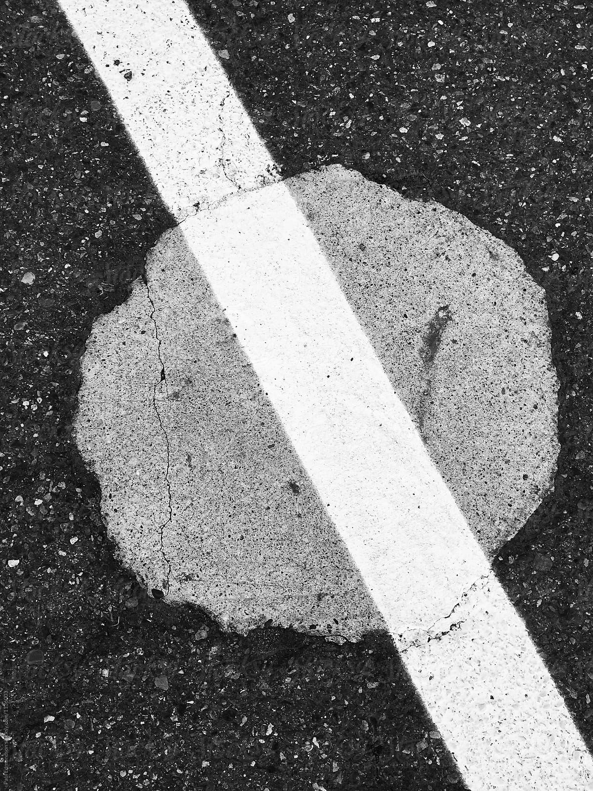 Close up of painted white stripe over asphalt and concrete circle