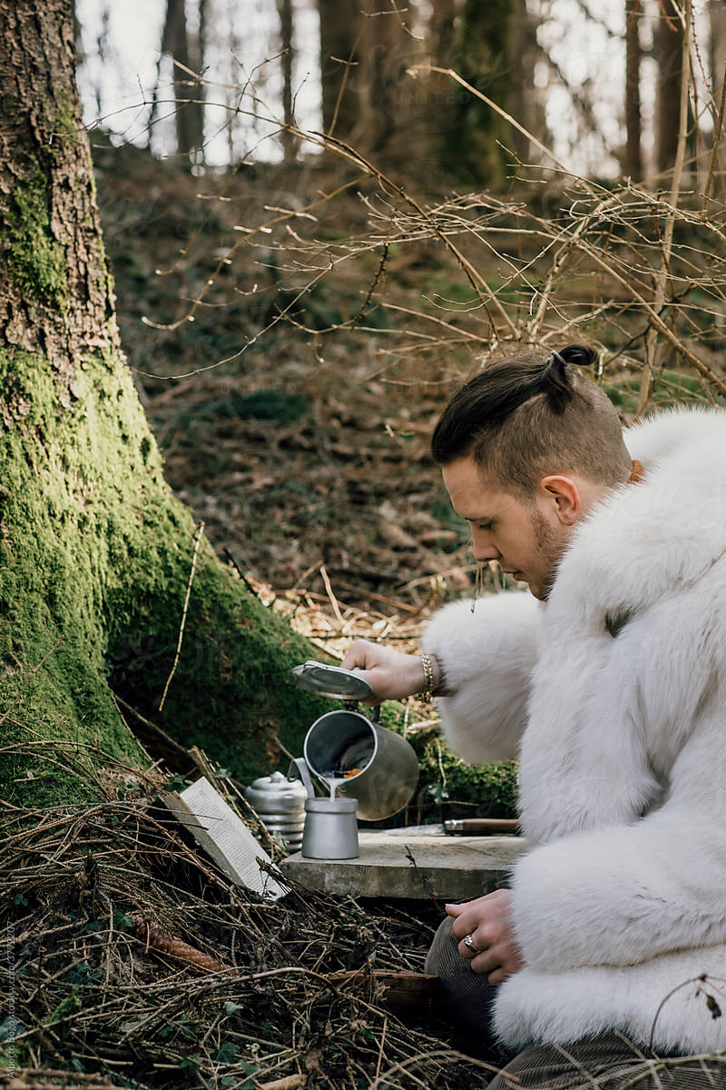 Young Man Pouring Milk For Breakfast In The Woods