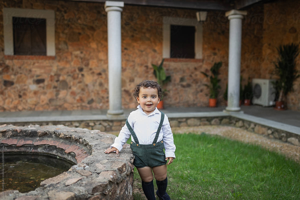 Adorable child next to a fountain in a country house in spring