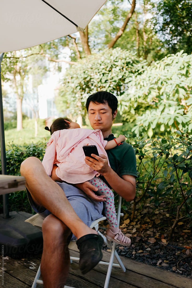Asian baby fell asleep on father\'s shoulder