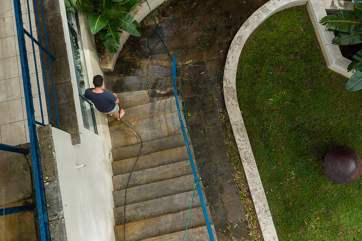 man cleaning stairs with high pressure water cleaner