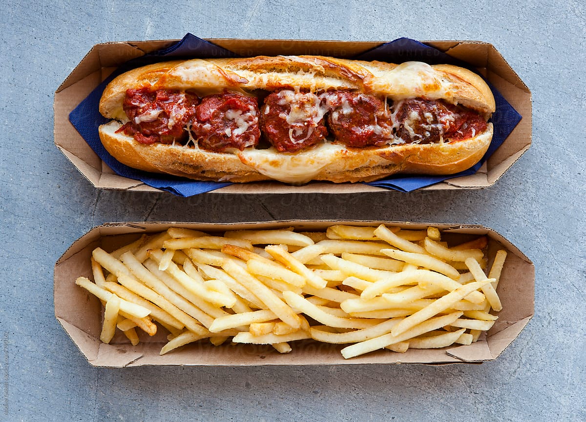 Meatball and cheese sub sandwich with fries