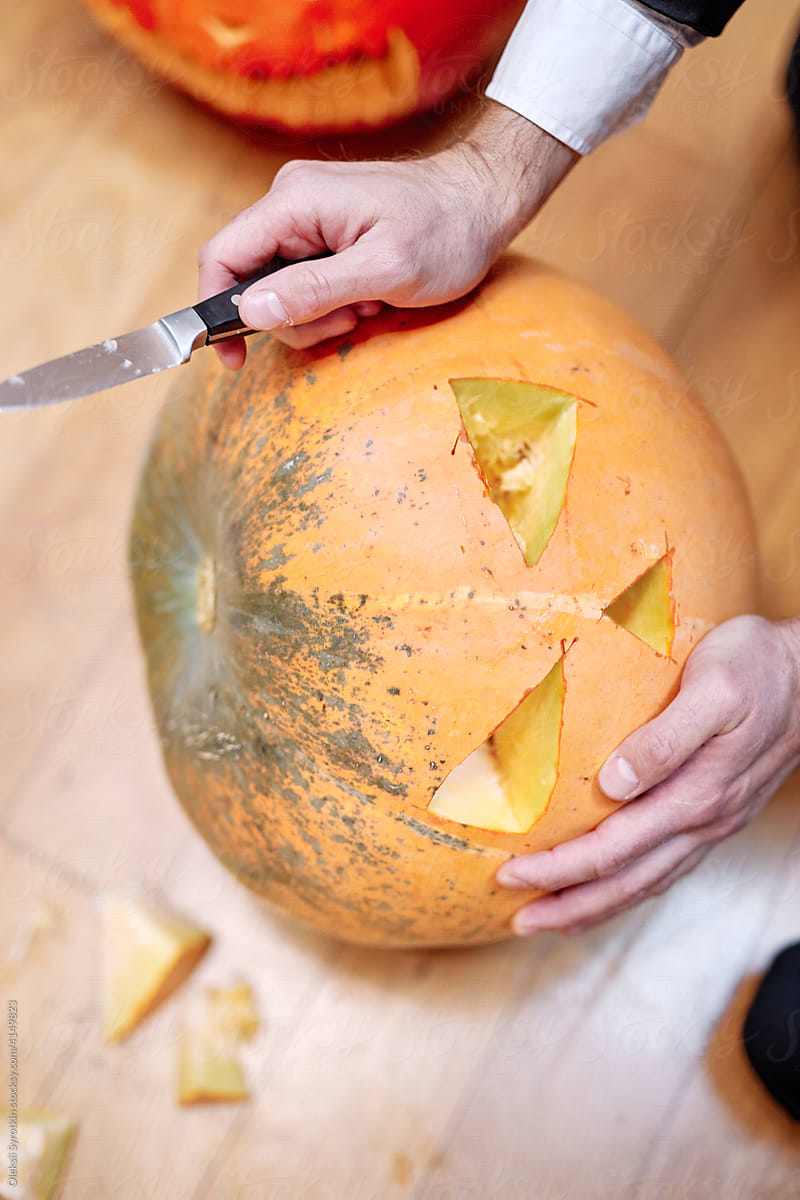Anonymous person carving pumpkin for Halloween